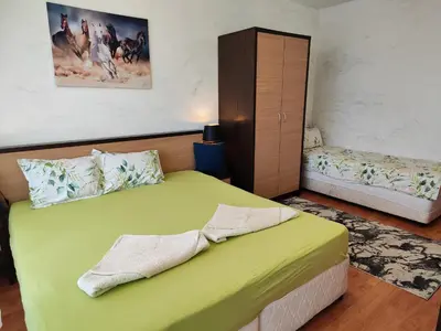a bedroom with a green bed and a cabinet at Nev 1 in Burgas City