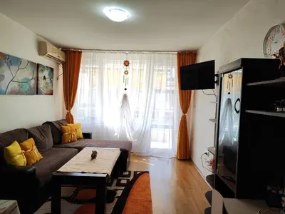 a living room with a couch and a table in front of a window at Nev 1 in Burgas City