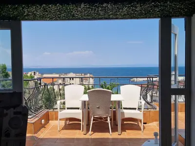 a table and chairs on a balcony with a view of the ocean at HOUSEDENz in Chernomorets