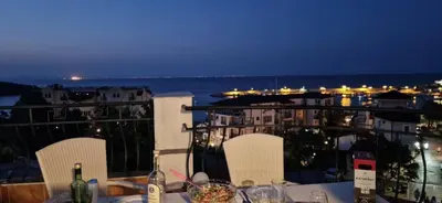 a table with a view of the ocean at night at HOUSEDENz in Chernomorets