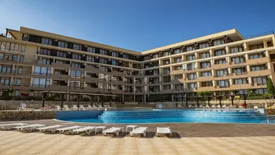 a hotel with a swimming pool and lounge chairs at Luxor Zaks Apartments in Sveti Vlas