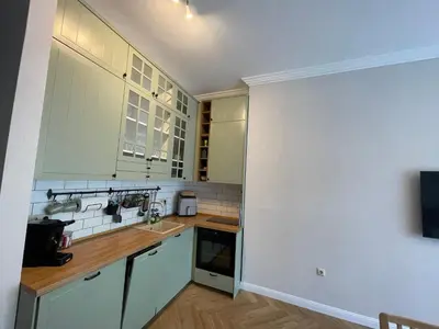 a kitchen with white cabinets and wooden counter tops at Coral Bay Studio Varna - Beachfront with Free Parking in Varna City