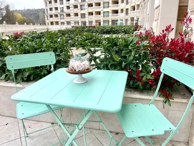 a blue table with two chairs and a vase on it at Coral Bay Studio Varna - Beachfront with Free Parking in Varna City