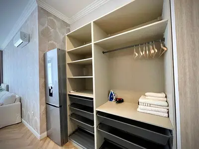 a walk in closet with a refrigerator and towels at Coral Bay Studio Varna - Beachfront with Free Parking in Varna City