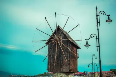 a large wooden windmill with two street lights at Apartment Rosa Marina in Nesebar
