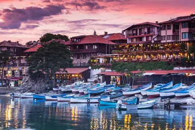 a group of boats sitting in the water in front of buildings at Apartment Rosa Marina in Nesebar