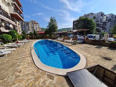 a large swimming pool with lounge chairs and buildings at MitProt Panorama bay 2 Luks Apartment 175 in Sveti Vlas