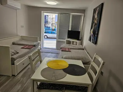 a room with two beds and a table with a hat on it at Студио за гости на град Бургас in Burgas City