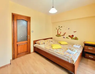 a bedroom with a bed and a wooden door at Sunny View Apartment with Garage in Burgas City