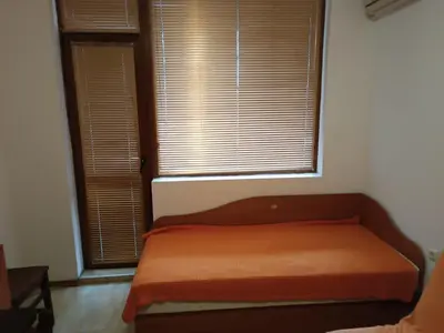 a bed in a room with a window with blinds at Stamopolu apartament 1 in Primorsko