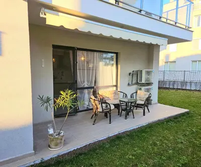 a deck with a table and chairs on a house at Sunny Garden Deluxe in Burgas City