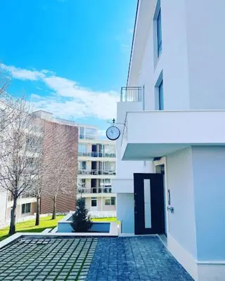 a building with a clock on the side of it at Sunny Garden Deluxe in Burgas City