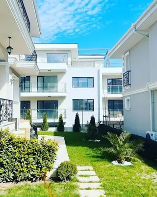a large white apartment building with a yard at Sunny Garden Deluxe in Burgas City