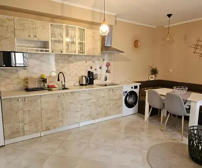 a kitchen with a sink and a table with chairs at Sunny Garden Deluxe in Burgas City