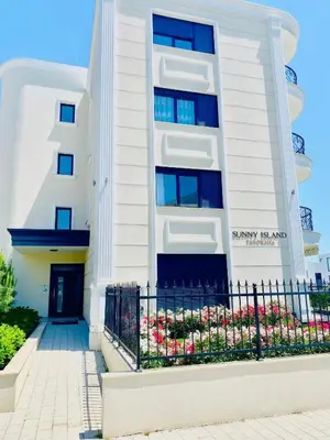 a white building with a fence in front of it at Rose Garden Deluxe in Chernomorets