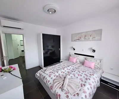 a bedroom with a large bed with pink pillows at Rose Garden Deluxe in Chernomorets