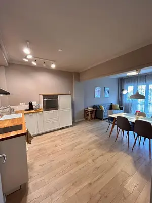 a kitchen and living room with a table and chairs at Sea Breeze l 2BD Sea Garden Apartment in Varna City