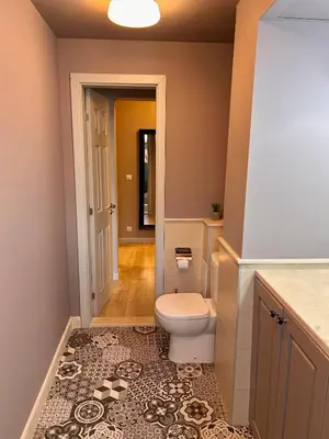 a bathroom with a toilet and a tile floor at Sea Breeze l 2BD Sea Garden Apartment in Varna City