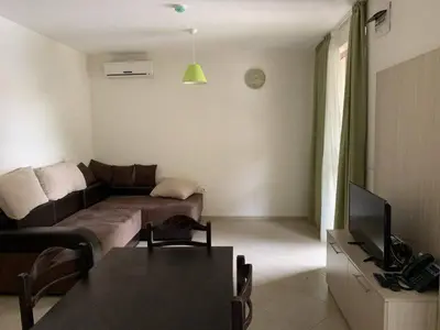 a living room with a couch and a television at Cascadas Family Resort in Sunny Beach