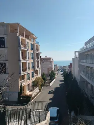 a city street with buildings and cars parked on the road at Studio Apartment Villa Sardinia Sveti Vlas in Sveti Vlas