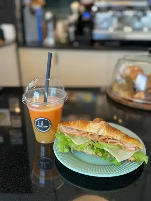 a sandwich on a plate and a drink on a table at Apartment Musala N 05 in Varna City