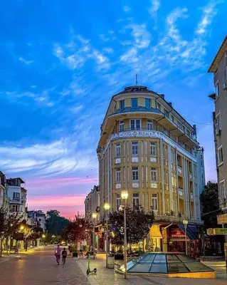 a large building on a city street at dusk at Apartment Musala N 06 in Varna City