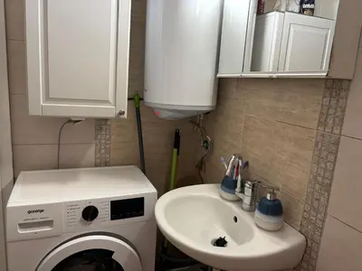 a bathroom with a washing machine and a sink at Sea Sunrise Apartment in Burgas City