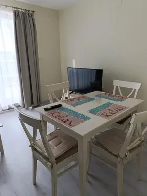 a white table with two chairs and a laptop on it at Sunny Beach Center Apartment in Sunny Beach