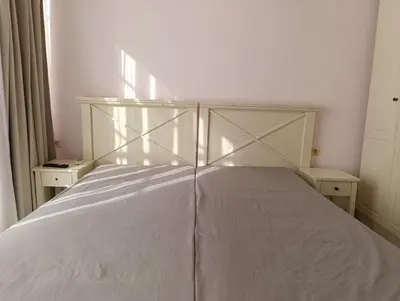 a white bed in a room with two night stands at Sunny Beach Center Apartment in Sunny Beach