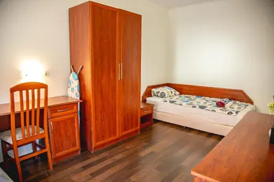 a small bedroom with a bed and a wooden cabinet at Nessebar's NEW Town TOP Centre 2-BDR Apartment by Flаt Manаger in Nesebar