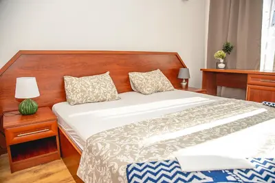 a bedroom with a large bed with a wooden headboard at Nessebar's NEW Town TOP Centre 2-BDR Apartment by Flаt Manаger in Nesebar