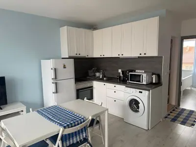 a kitchen with white cabinets and a table and a microwave at Lora - Tsarevo in Tsarevo