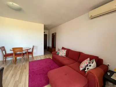 a living room with a red couch and a table at Holiday Fort Golf Club MIA 2 in Sunny Beach