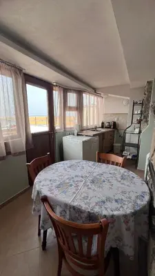 a dining room with a table and chairs and a kitchen at Cozi 2BD Apartment with Sea View in the Old Town of Sozopol in Sozopol