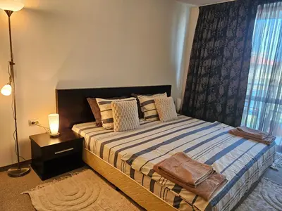 a bedroom with a large bed with a window at Студио за нощувки в Сарафово in Burgas City