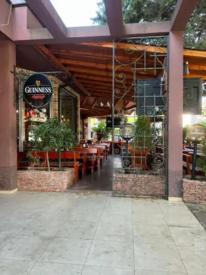 a restaurant with wooden tables and chairs and a sign at Студия в Болгарии Солнечный берег in Sunny Beach