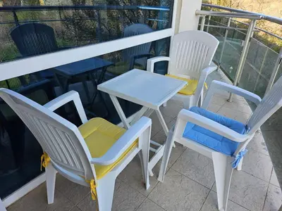 three chairs and a table on a balcony at Студио за гости на Сарафово in Burgas City