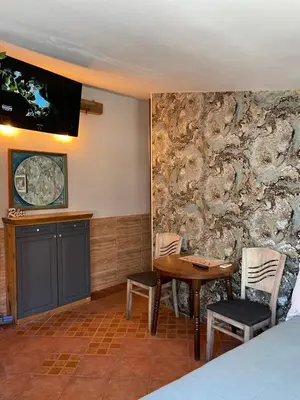 a room with a stone wall with a table and a tv at Art Luxury studio in Burgas City