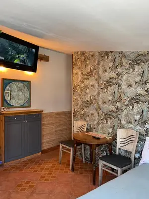 a room with a stone wall with a table and chairs at Art Luxury studio in Burgas City