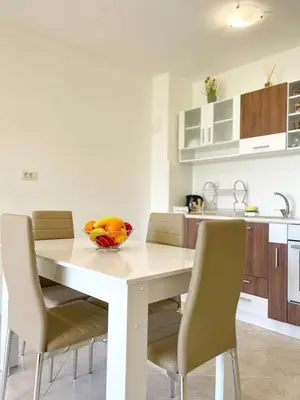 a kitchen with a table with chairs and a bowl of fruit on it at К-с Сън Коуст in Sveti Vlas