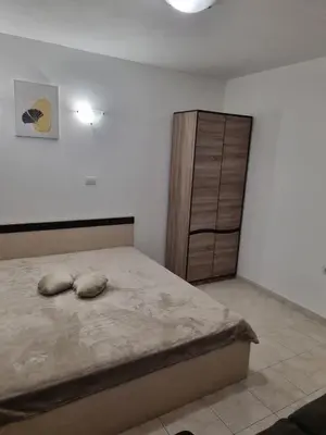 a bedroom with a bed and a wooden cabinet at К-с Сън Коуст in Sveti Vlas