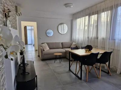 a living room with a couch and a table and chairs at Apart VILLA ITTA Sunny Beach in Sunny Beach
