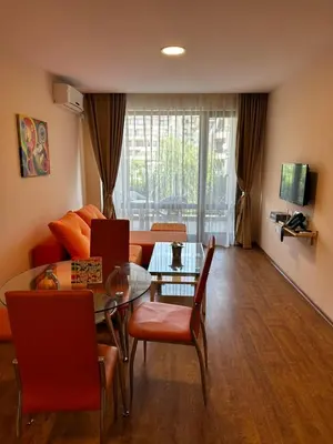 a living room with a table and a couch at Premier Fort Beach Hotel in Sveti Vlas