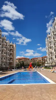 a large swimming pool in a resort with buildings at Sunshine Rose - Sea view, Neubau, Luxus Apartment in Sveti Vlas