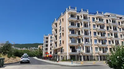 a large building with cars parked in front of it at Sunshine Rose - Sea view, Neubau, Luxus Apartment in Sveti Vlas
