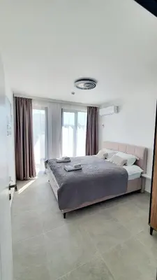 a bedroom with a large bed and a large window at Sunshine Rose - Sea view, Neubau, Luxus Apartment in Sveti Vlas