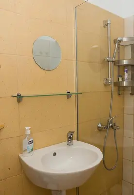a bathroom with a sink and a shower with a mirror at Verano Azul - Adorable Flat in Unbeatable Location by Flat Mаnager in Varna City