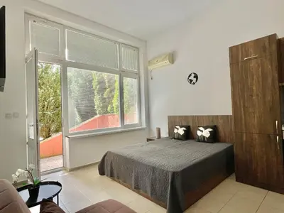 a bedroom with a bed and a large window at Green Fort Noks - Private apartment - BSR - 3 in Sunny Beach