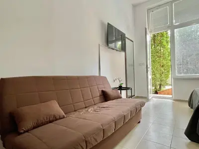 a brown couch in a living room with a window at Green Fort Noks - Private apartment - BSR - 3 in Sunny Beach