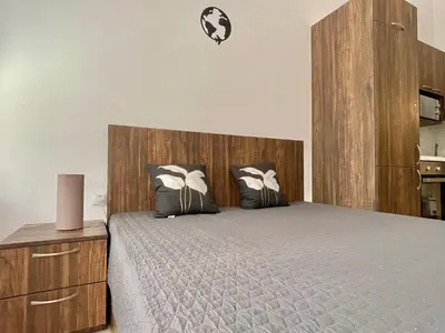 a bedroom with a large bed with a wooden headboard at Green Fort Noks - Private apartment - BSR - 3 in Sunny Beach
